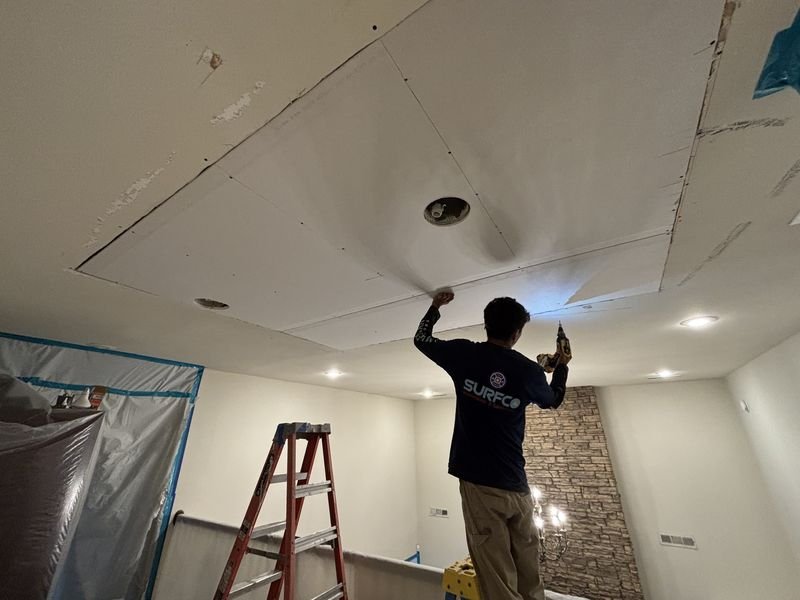Surfco technician replacing water damaged ceiling drywall in a Northwest Arkansas home